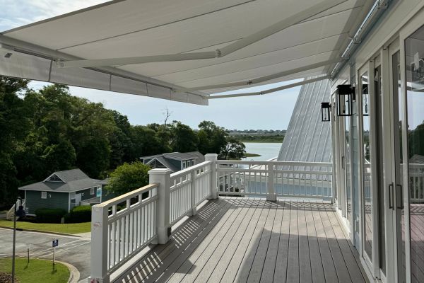 overlooking the water from a deck covered by an ogden retractable awning
