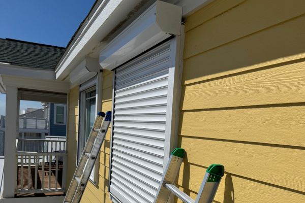 small window with white roll down hurricane shutters in kure beach north carolina