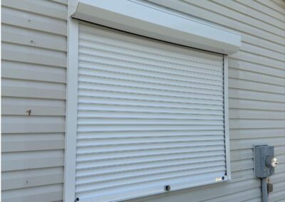 White push and pull hurricane shutter installed over a window