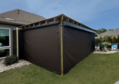 Covered Pavilion wrapped in black hurricane screens for privacy